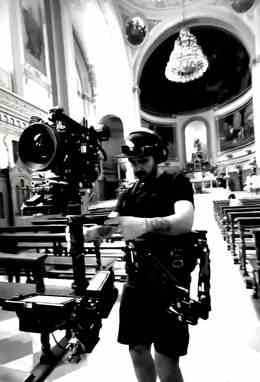 Héctor Flores operando cámara con Steadicam dentro de un templo, foto en blanco y negro.
